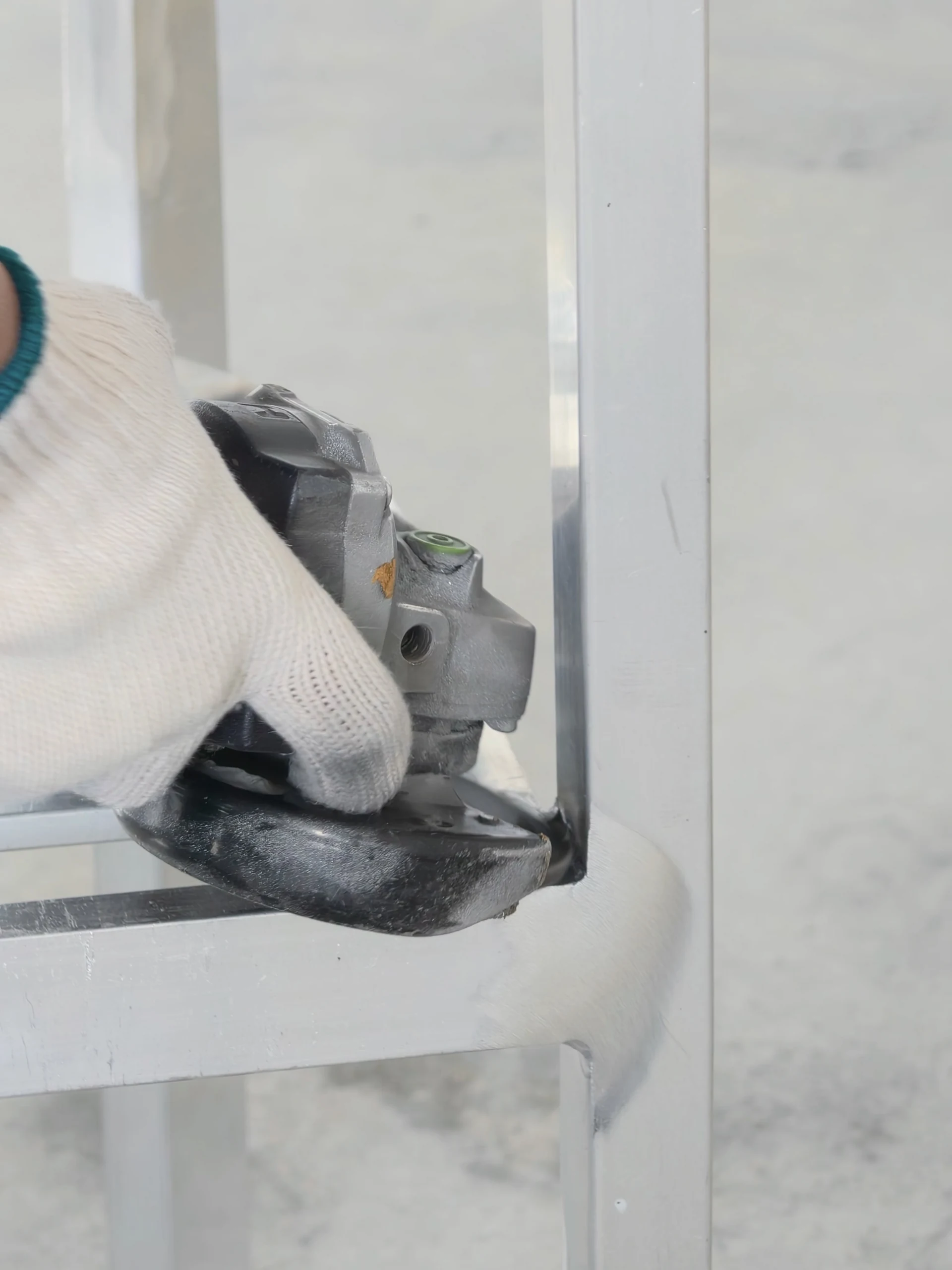 Grinding a joint on a metal furniture frame.